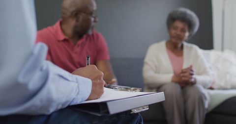 Senior counselor advising elderly couple in therapy session
