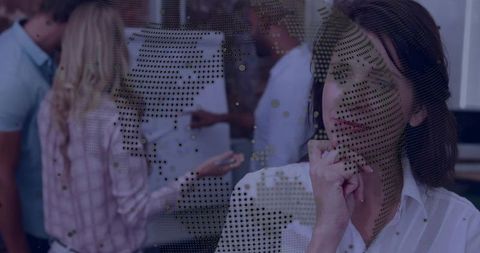 Contemplative businesswoman watching team brainstorming through dotted world-map glass