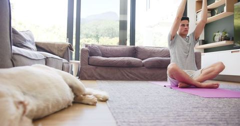 Man Practicing Yoga Indoors with Peaceful Sleeping Dog by His Side