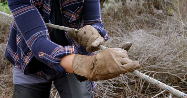 Worker in Plaid Shirt and Gloves Pulling Rope Outdoors - Download Free Stock Images Pikwizard.com