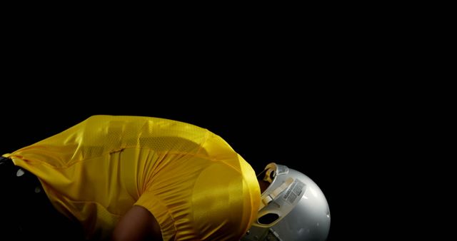 Football Player in Yellow Uniform Bowing Under Dramatic Light - Download Free Stock Images Pikwizard.com