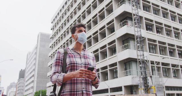 Urban Professional Wearing Face Mask Checking Phone in Modern City - Download Free Stock Images Pikwizard.com