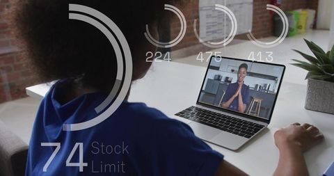Over-shoulder remote video meeting on laptop with circular hud data overlays, modern workspace