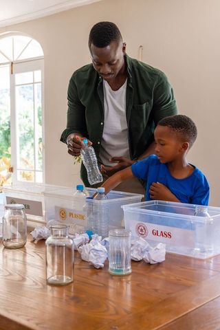 African american father and son sorting recyclables at home teaching eco friendly habits
