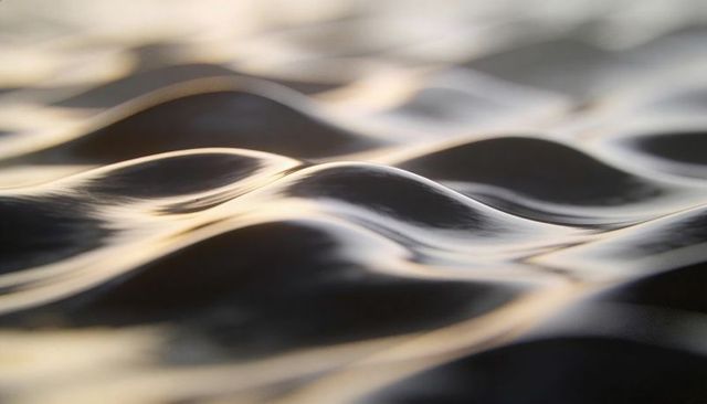Gliding water ripples reflecting sunrise light on calm lake surface close-up abstract