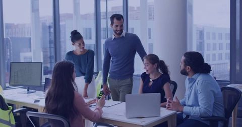 Multicultural Team Collaborating in Modern Office Space with Architecture Plans