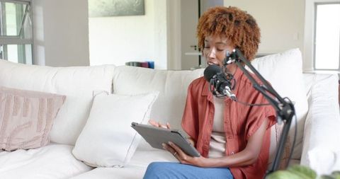 Recording cozy living room podcast on couch using tablet and adjustable boom microphone