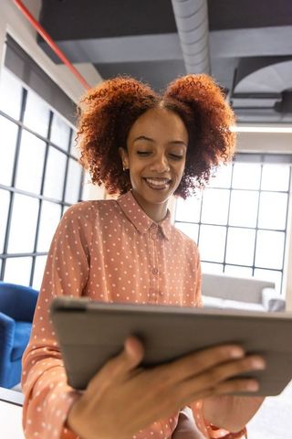 Confident african american woman engaging with digital technology in modern office