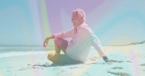 Joyful Senior Sitting on Sandy Beach Gazing at Ocean Waves