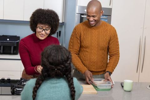 Parents preparing meal with child at kitchen island sharing joyful family bonding