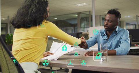 Business partners shaking hands while reviewing sustainability reports with energy icons