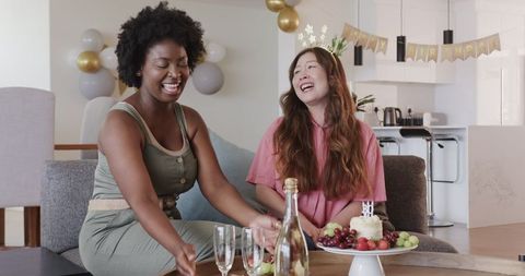 Joyful Lesbian Couple Celebrating Birthday with Cake and Candles
