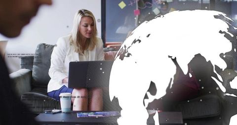 Working businesswoman on laptop in modern lounge with global network overlay and coffee
