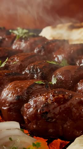 Sizzling juicy kofta kebabs grilling over charcoal embers with herb garnish