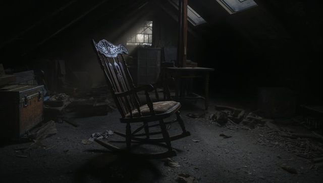 Ornate rocking chair in dusty attic with sunlight
