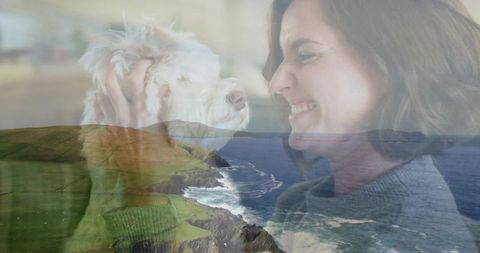 Smiling woman cradling dog with coastal double exposure, intimate pet bond