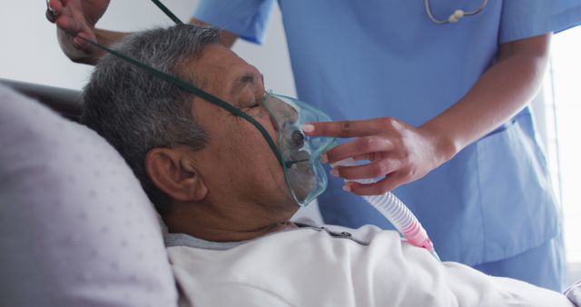Biracial female doctor assisting senior man in bed at home using ventilator - Download Free Stock Photos Pikwizard.com