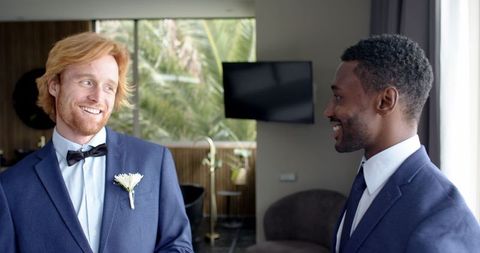Groom and best man sharing joyful moment before wedding
