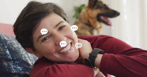 Woman Smiling on Sofa Relaxing with Dog in Cozy Living Room