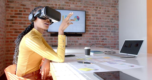 Businesswoman using virtual reality headset in modern office, engaging with digital content. Ideal for depicting innovation, technology integration, digital transformation in professional settings. Perfect for articles, websites, or marketing materials about modern work environments, VR technology in business, or employee use of advanced tech.