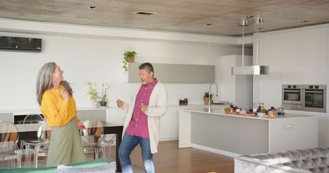 Senior Couple Dancing Joyfully in Modern Kitchen Interior