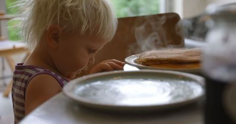 Curious Child Looking at Hot Pancakes in Cozy Kitchen