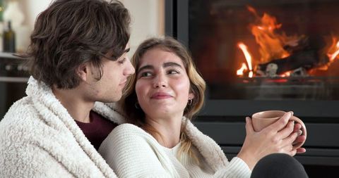 Romantic Couple by Fireplace Enjoying Cozy Moments at Home