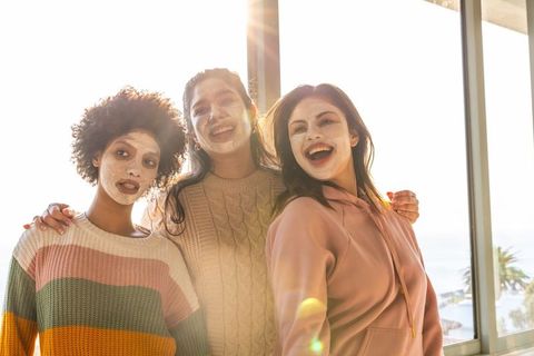 Sunlit self-care with diverse women wearing facial masks and cozy knitwear