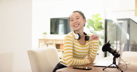 Smiling Woman Podcasting in Bright Home Office