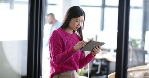 Asian Businesswoman Using Tablet in Contemporary Office