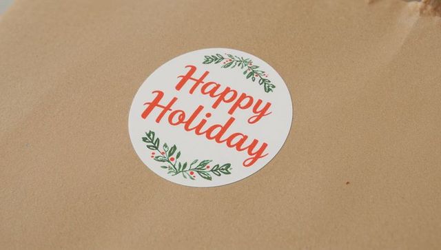 Happy holiday round sticker on kraft paper gift wrap label with holly berries