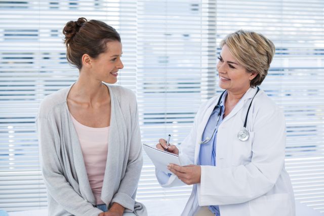 Female doctor consulting a patient, engaged in friendly communication. Useful for marketing medical services, illustrating healthcare articles, or educational materials on doctor-patient interactions.