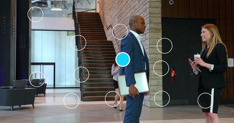 Colleagues Engaging in Conversation in Modern Office Lobby