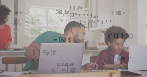 Father and Son Coding on Laptops with Digital Interface Overlay