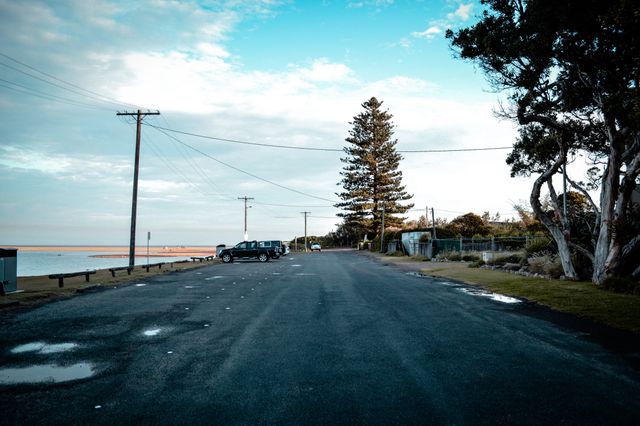 Empty Coastal Road Near Beach with Parked Cars - Download Free Stock Photos Pikwizard.com