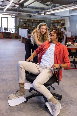 Diverse Coworkers Laughing in Modern Office Foster Team Spirit