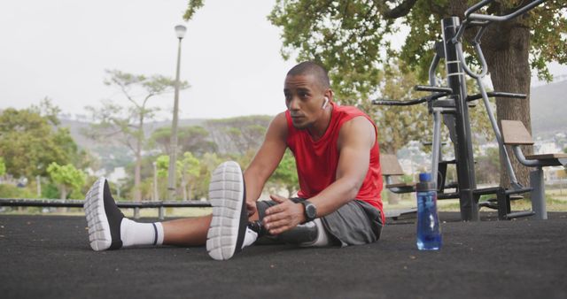 Biracial man exercising at gym outdoors with his prosthetic leg in park. Sport, active lifestyle and disability.