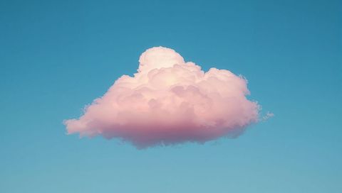 Floating pastel pink cumulus cloud drifting over clear cyan sky minimalist serene background