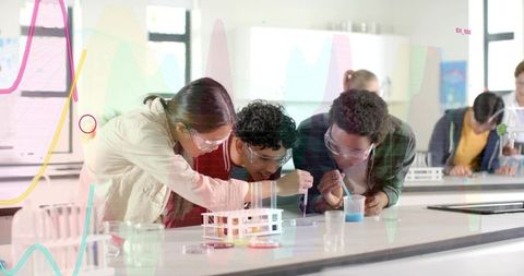 Teen Students Conducting Color Chemistry Experiment in Classroom Lab Wearing Safety Goggles