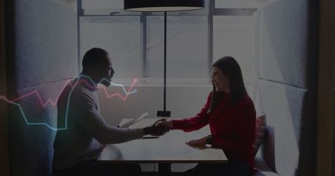 Confident business meeting shaking hands in modern office booth
