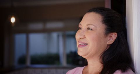 Smiling Mature Woman Standing Indoor with Joyful Expression