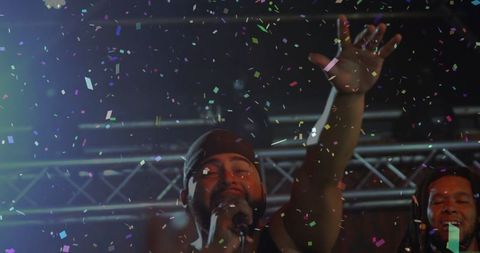 Energetic Singer Performing on Stage Amidst Falling Confetti