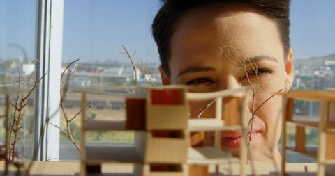 Female architect examining building model in modern office