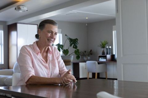 Senior woman engaging in conversation at modern home workspace