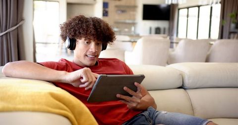 Young Man Relaxing with Tablet and Headphones at Home