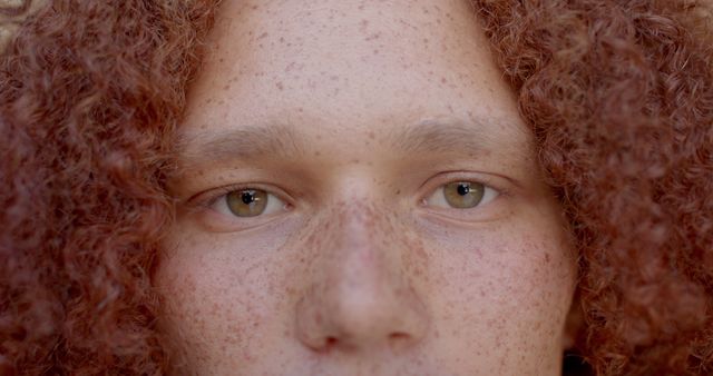 Portrait of eyes of caucasian man with ginger curly hair and freckles at sunny home. Lifestyle and domestic life, unaltered.