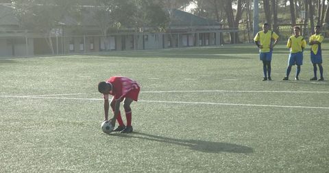 Soccer Player Preparing Free Kick on Sunny Field During Game