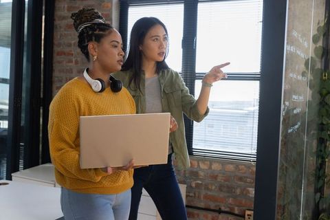 Diverse Female Coworkers Discussing Ideas in Modern Office