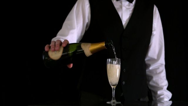 Waiter pouring champagne into a flute, for celebration or special event settings, ideal for hospitality promotion