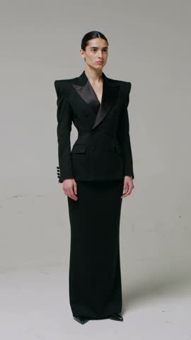 Vertical catalog video: Model rotating to full front in black double-breasted blazer and skirt